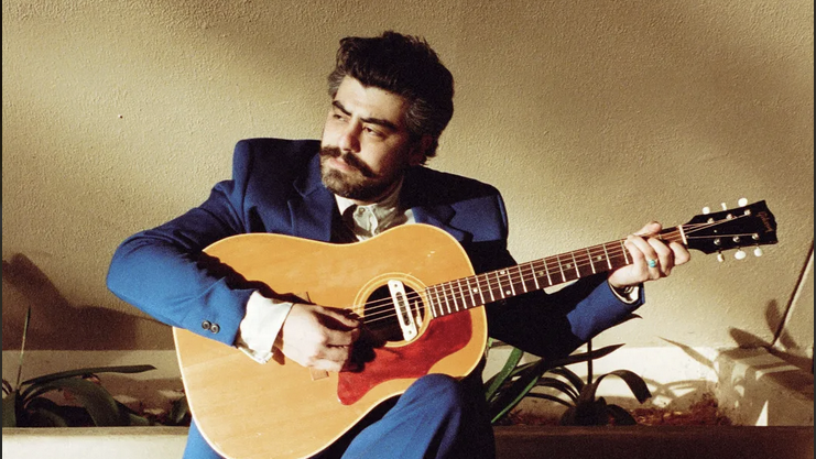 R.O. Shapiro holding a guitar.